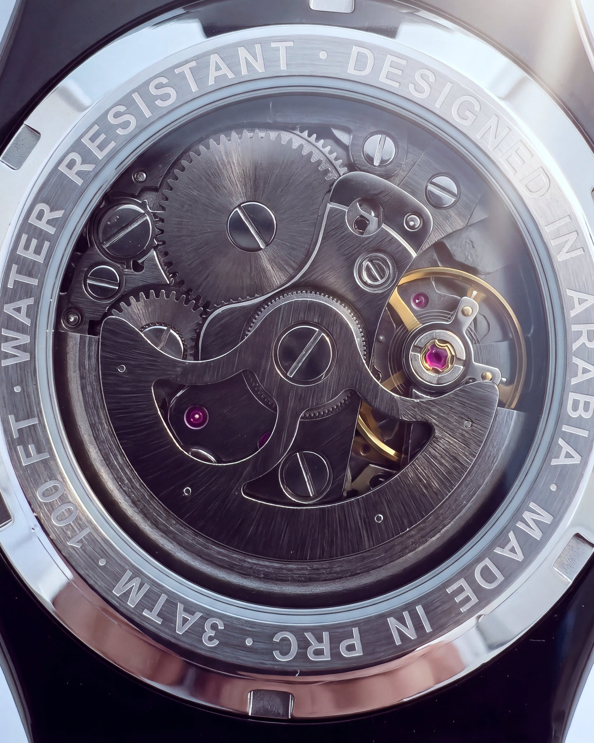 The exhibition caseback: the automatic movement inside a ring engraved Designed in Arabia