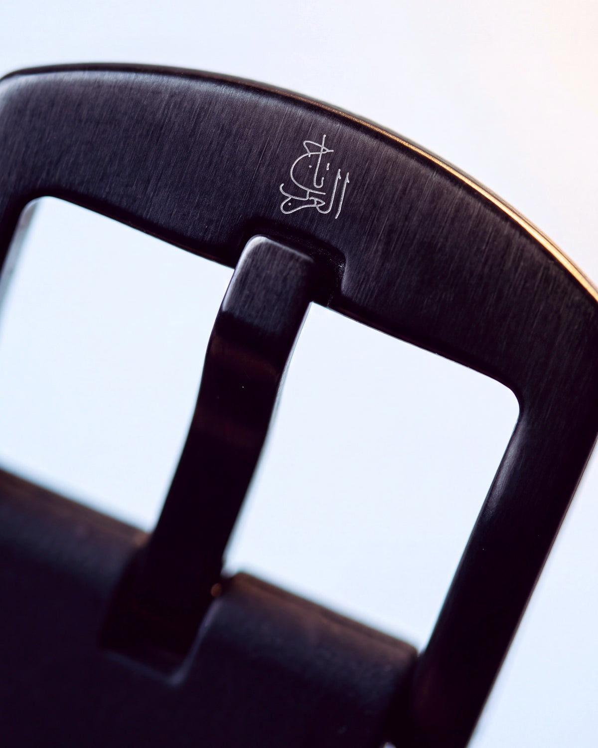 The black pin buckle, engraved with the house mark